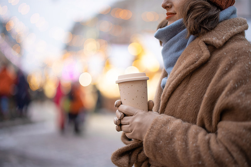 Woman with takeaway coffee on the Christmas market